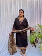 Woman wearing a black ethnic printed kurta set with matching pants and dupatta, featuring traditional motifs and a V-neck design.