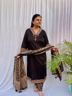 Woman wearing a black ethnic printed kurta set with matching pants and dupatta, featuring traditional motifs and a V-neck design.