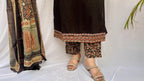 Woman wearing a black ethnic printed kurta set with matching pants and dupatta, featuring traditional motifs and a V-neck design.