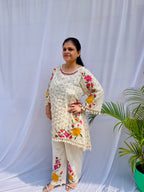 Elegant ivory white chanderi silk tunic co-ord set with large colorful floral embroidery, tassel fringe, and matching embroidered pants.