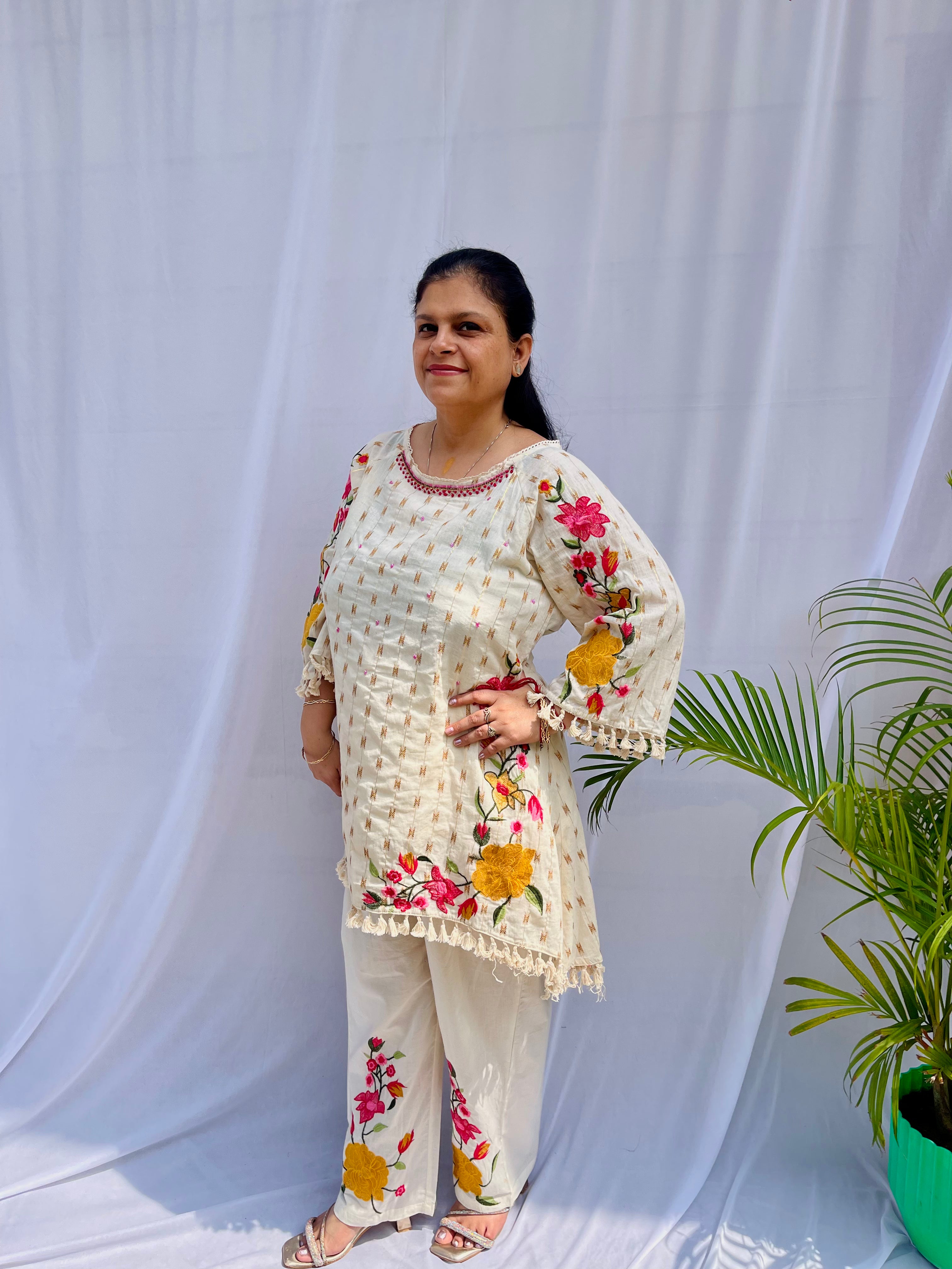 Elegant ivory white chanderi silk tunic co-ord set with large colorful floral embroidery, tassel fringe, and matching embroidered pants.