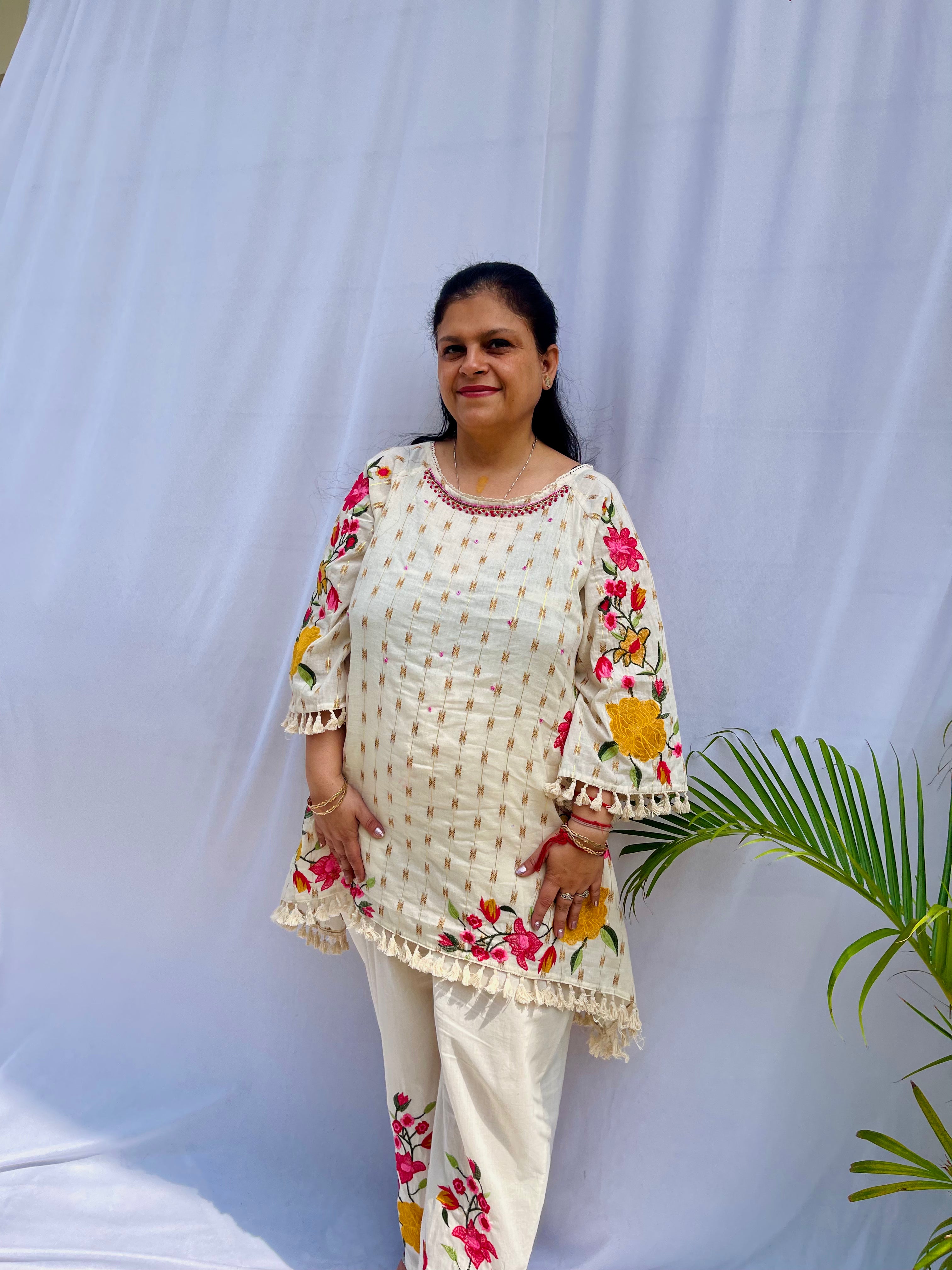 Elegant ivory white chanderi silk tunic co-ord set with large colorful floral embroidery, tassel fringe, and matching embroidered pants.