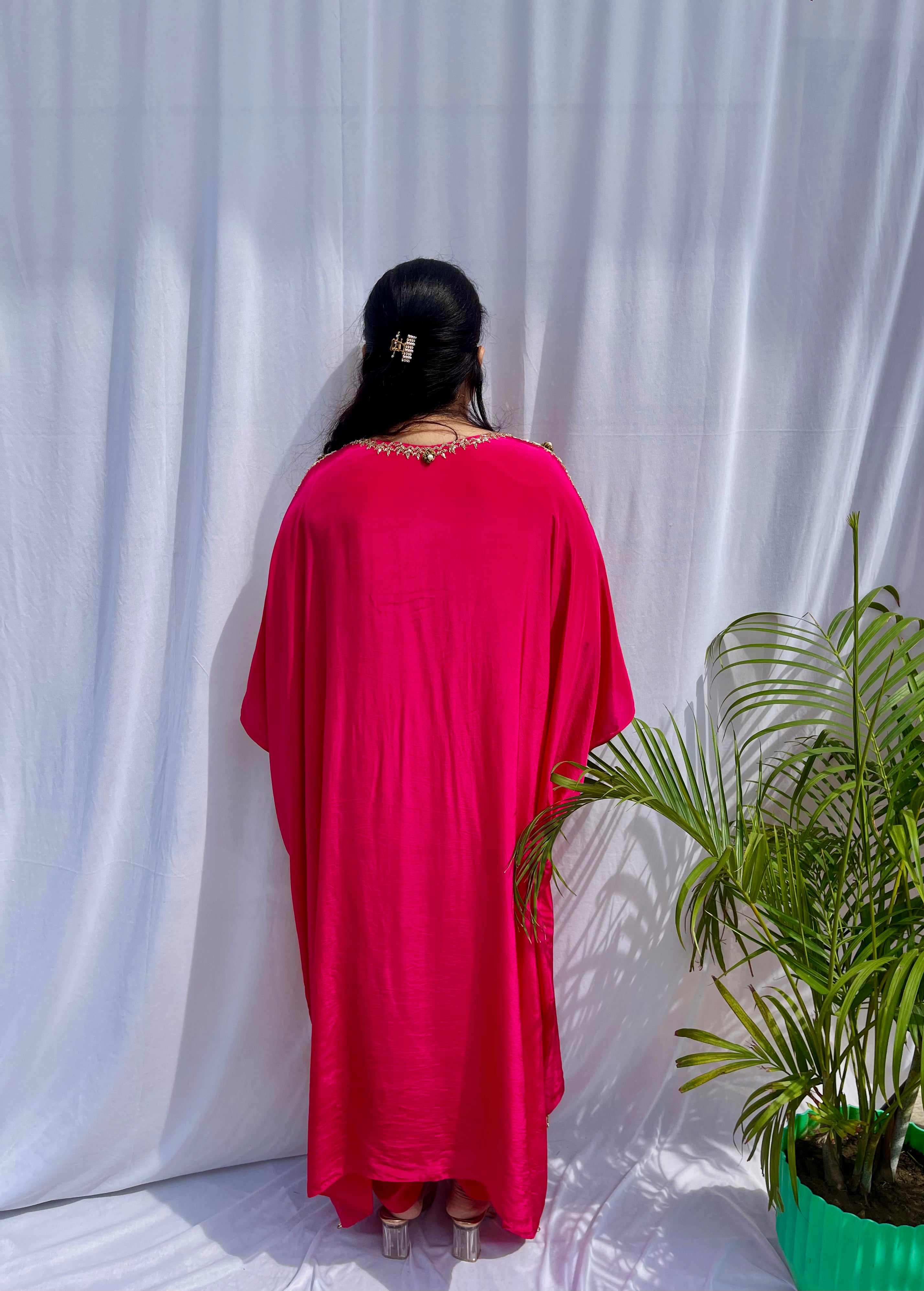 Vibrant fuchsia pink silk kaftan dress with intricate gold zardozi embroidery and crystal work on the neckline and sleeves.