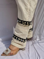 Black and white polka dot tunic featuring a V-shaped mirror work yoke, lace inserts, and matching white pants with mirror detailing.