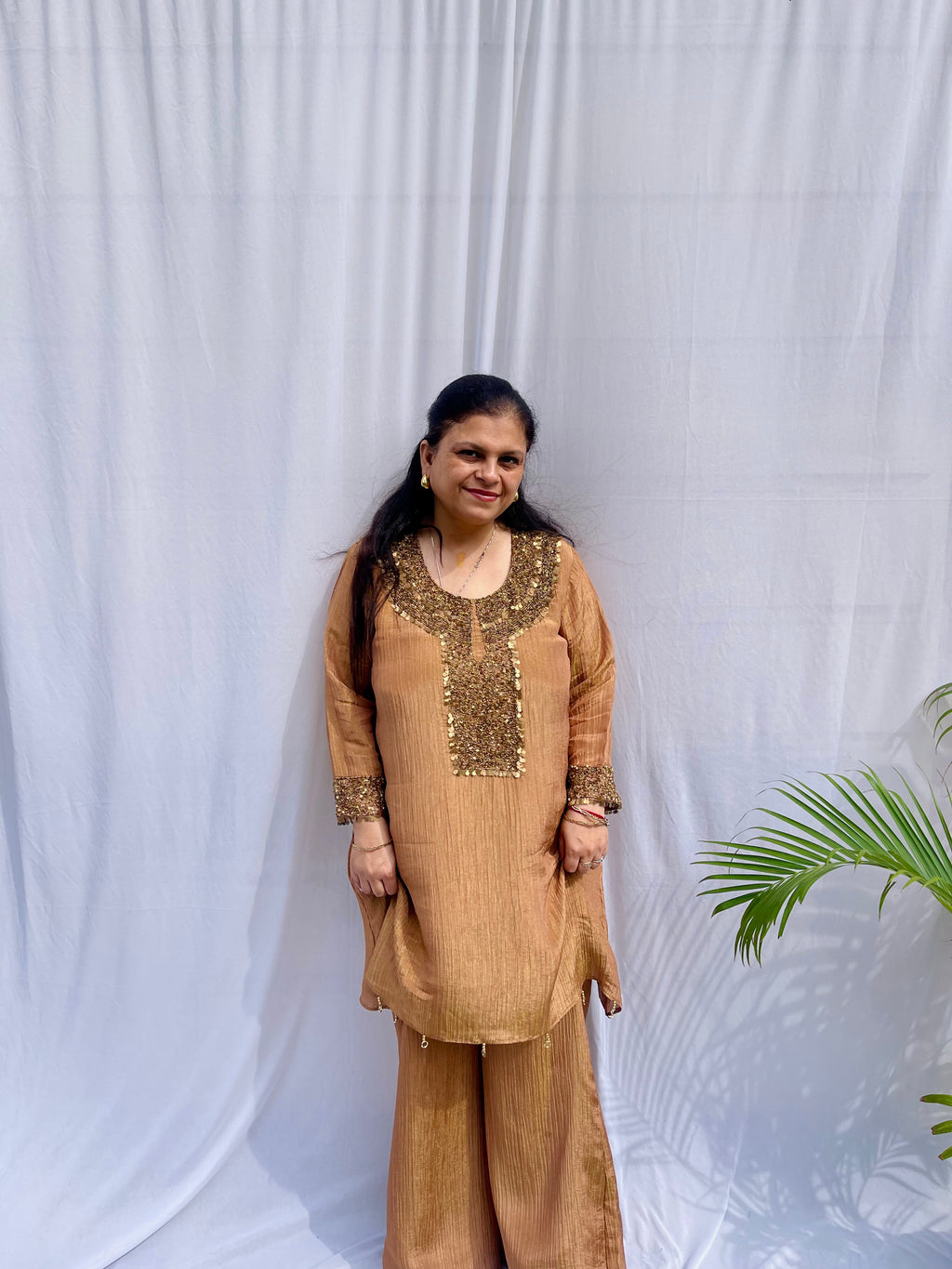 Antique gold crinkled silk ensemble with a heavily embellished sequin neckline and wide-leg flared palazzos.