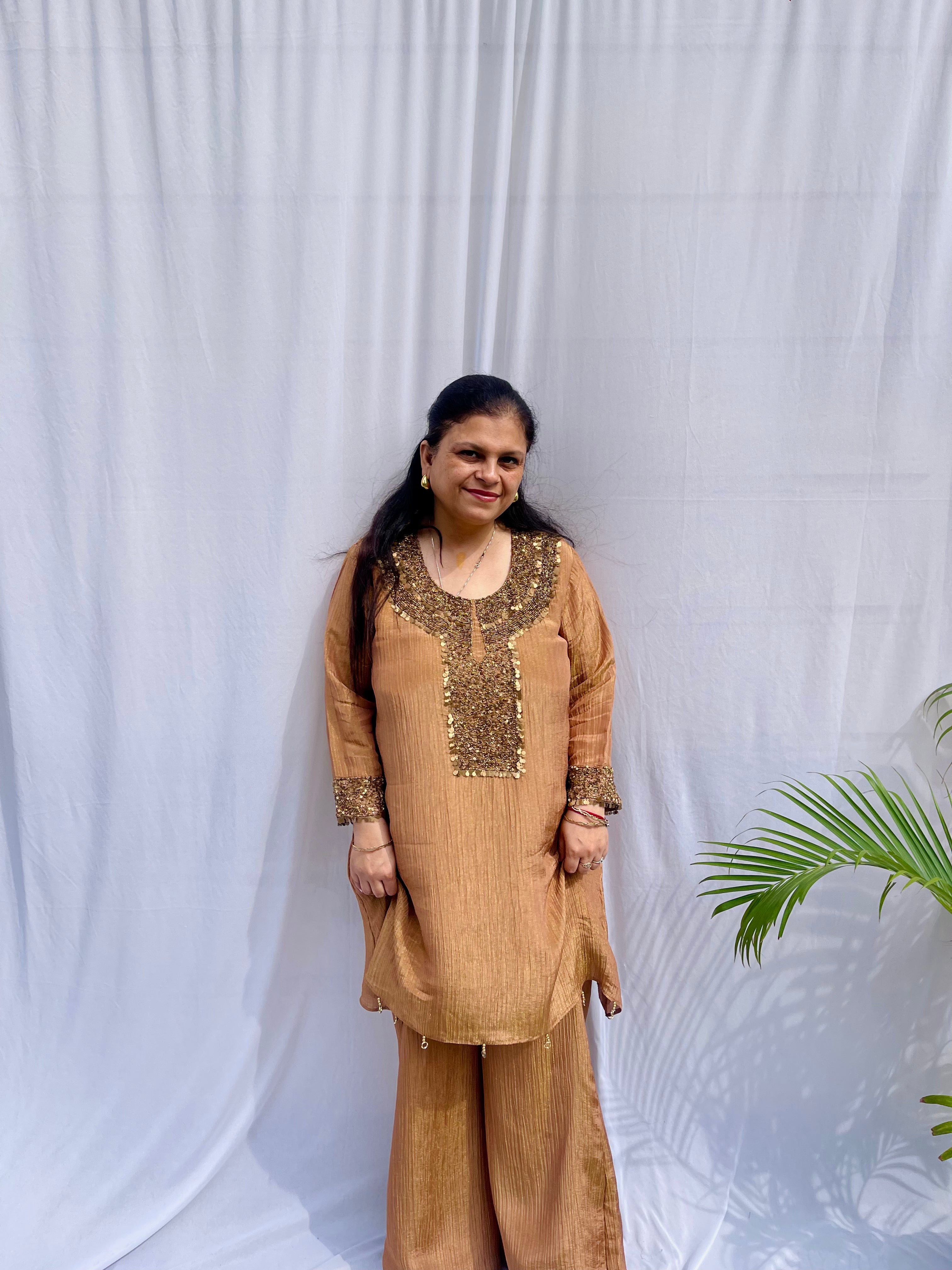 Antique gold crinkled silk ensemble with a heavily embellished sequin neckline and wide-leg flared palazzos.