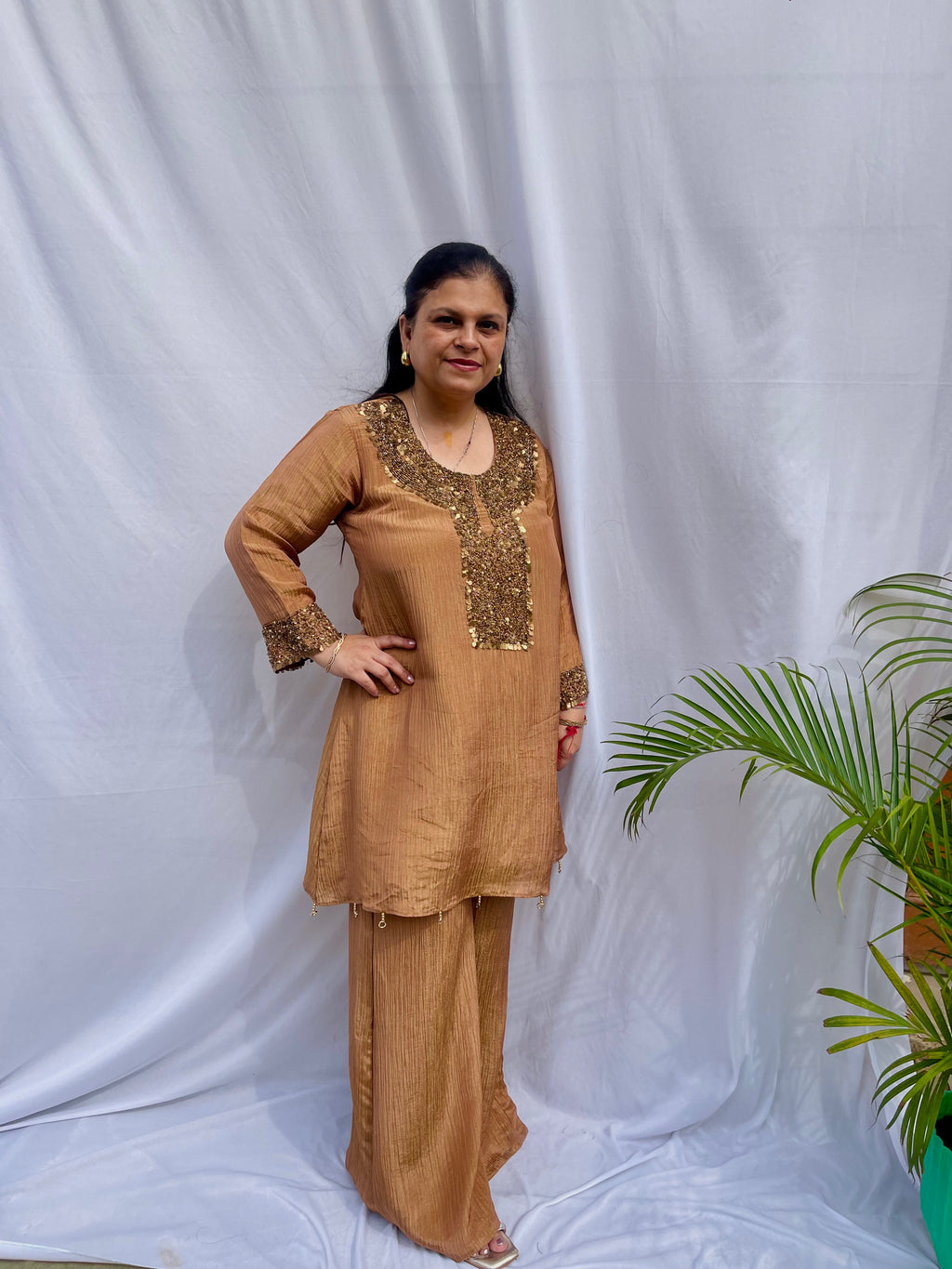 Antique gold crinkled silk ensemble with a heavily embellished sequin neckline and wide-leg flared palazzos.
