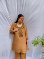 Antique gold crinkled silk ensemble with a heavily embellished sequin neckline and wide-leg flared palazzos.