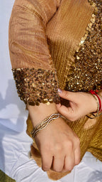 Antique gold crinkled silk ensemble with a heavily embellished sequin neckline and wide-leg flared palazzos.
