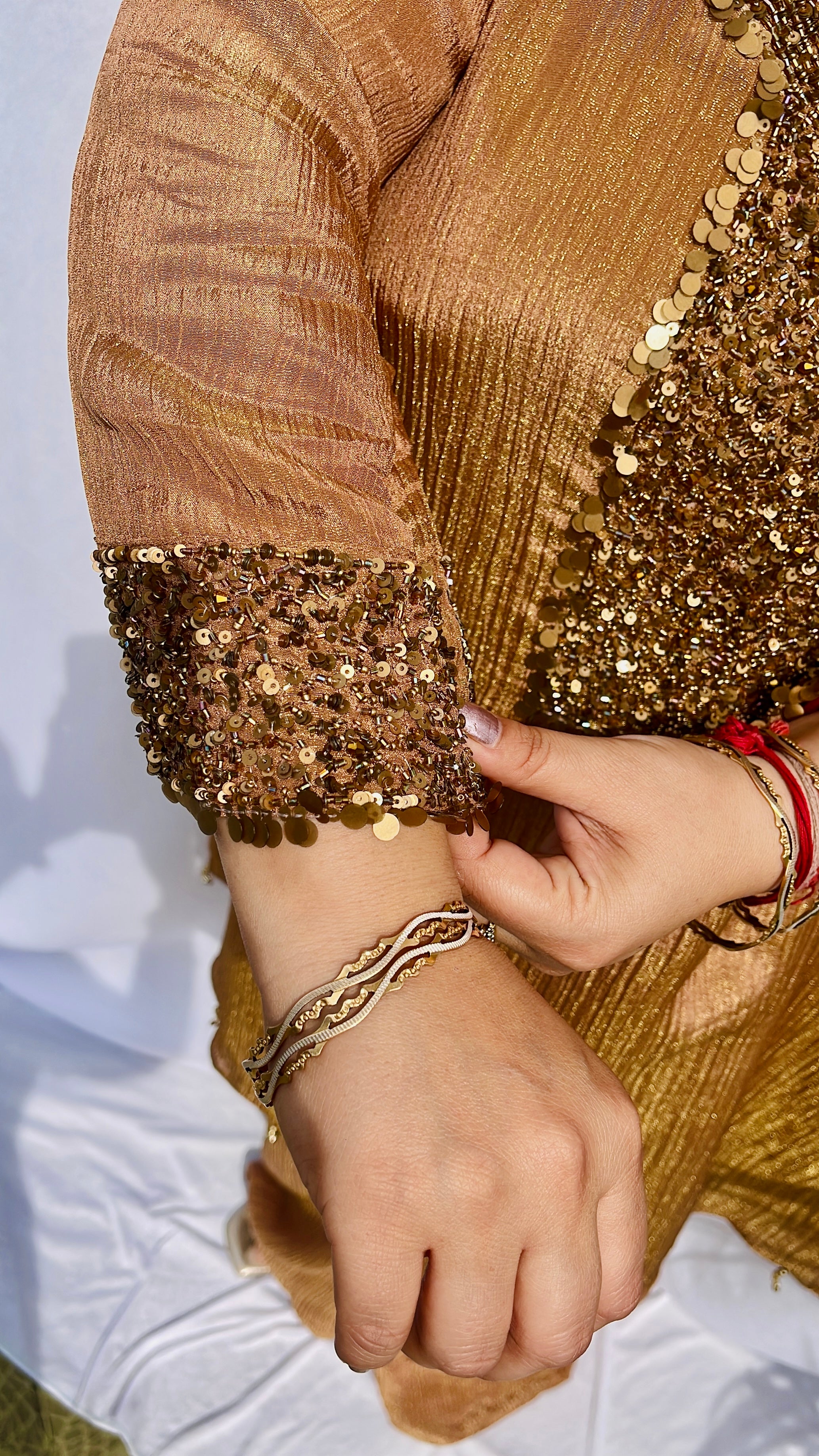 Antique gold crinkled silk ensemble with a heavily embellished sequin neckline and wide-leg flared palazzos.