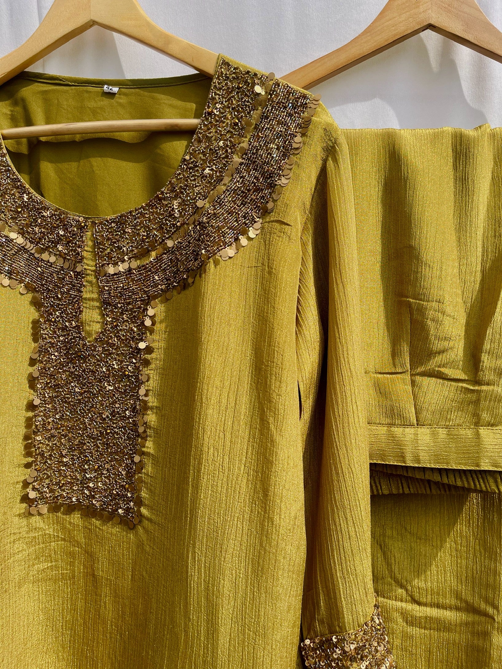 Antique green crinkled silk ensemble with a heavily embellished sequin neckline and wide-leg flared palazzos.