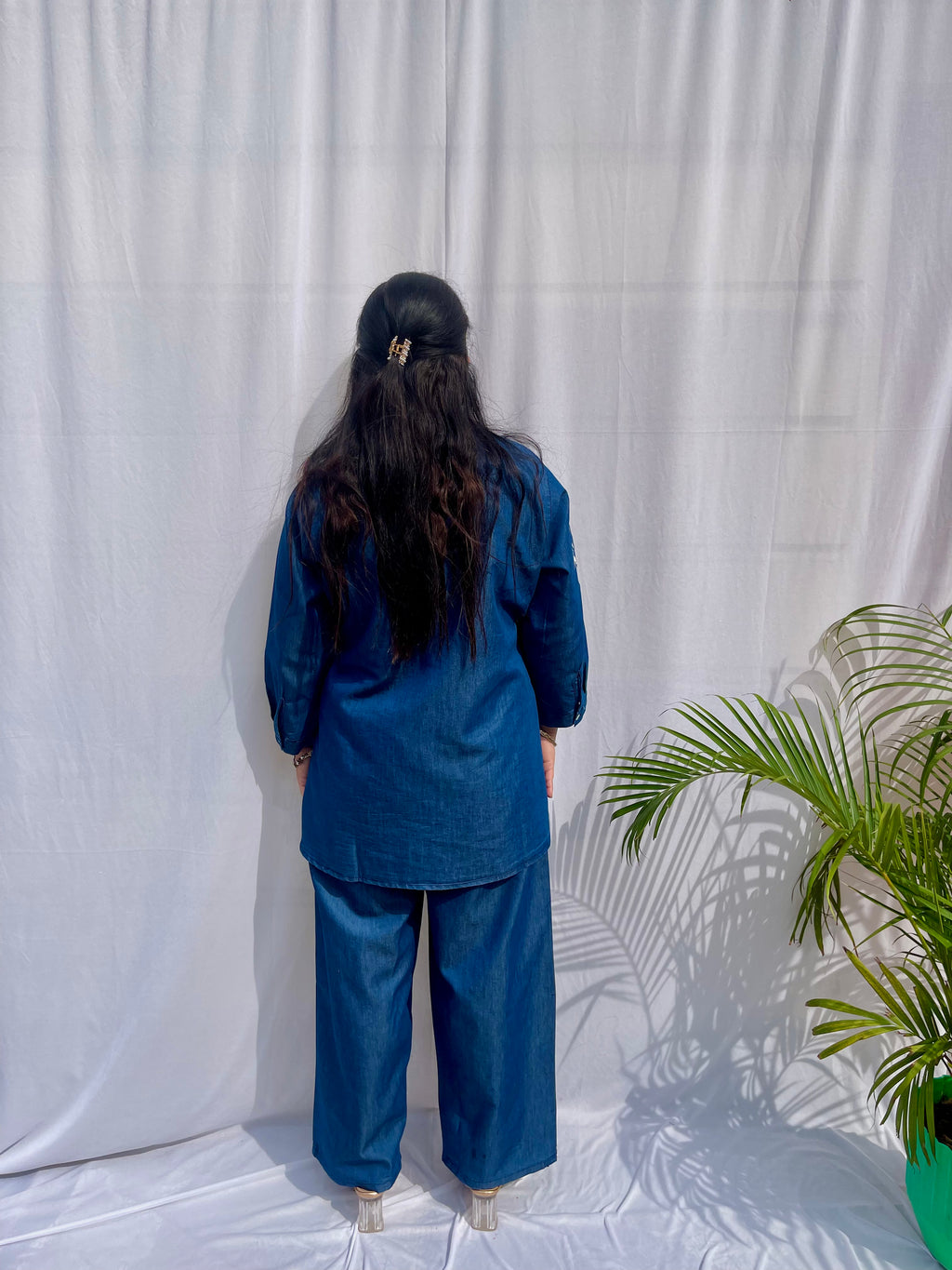 Denim-finish indigo blue shirt set with a large white leaf thread-work embroidery on the right shoulder and sleeve.
