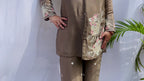 Woman in a metallic bronze silk shirt set with delicate pastel floral threadwork on the collar, hem, and cuffs.