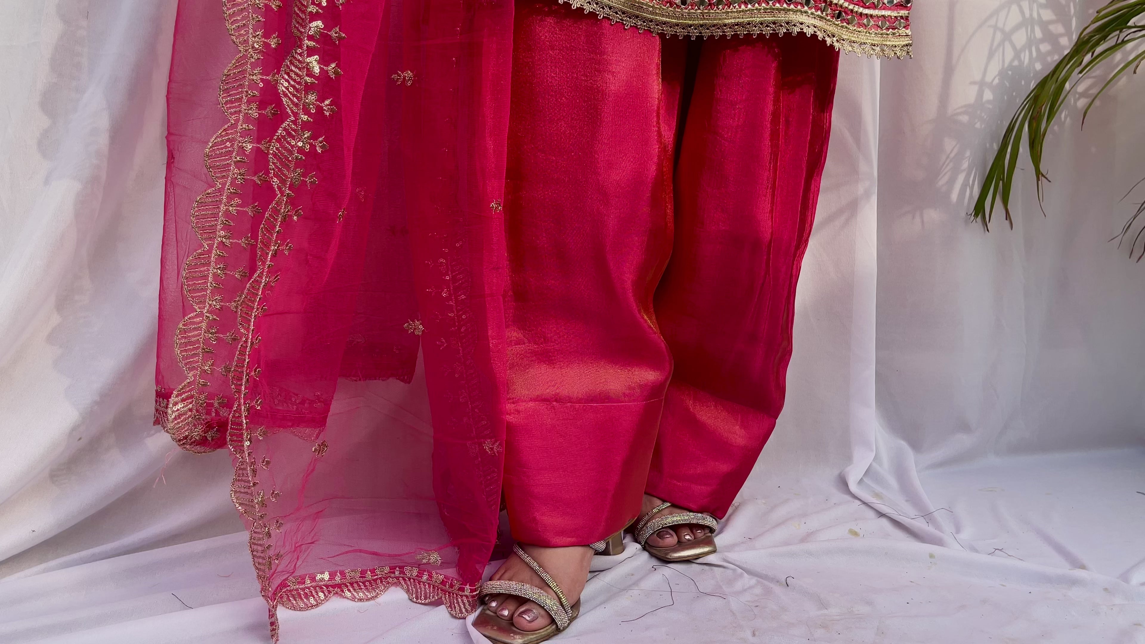 Close up of hot pink farshi salwar embroidery and dupatta border detailing with intricate threadwork