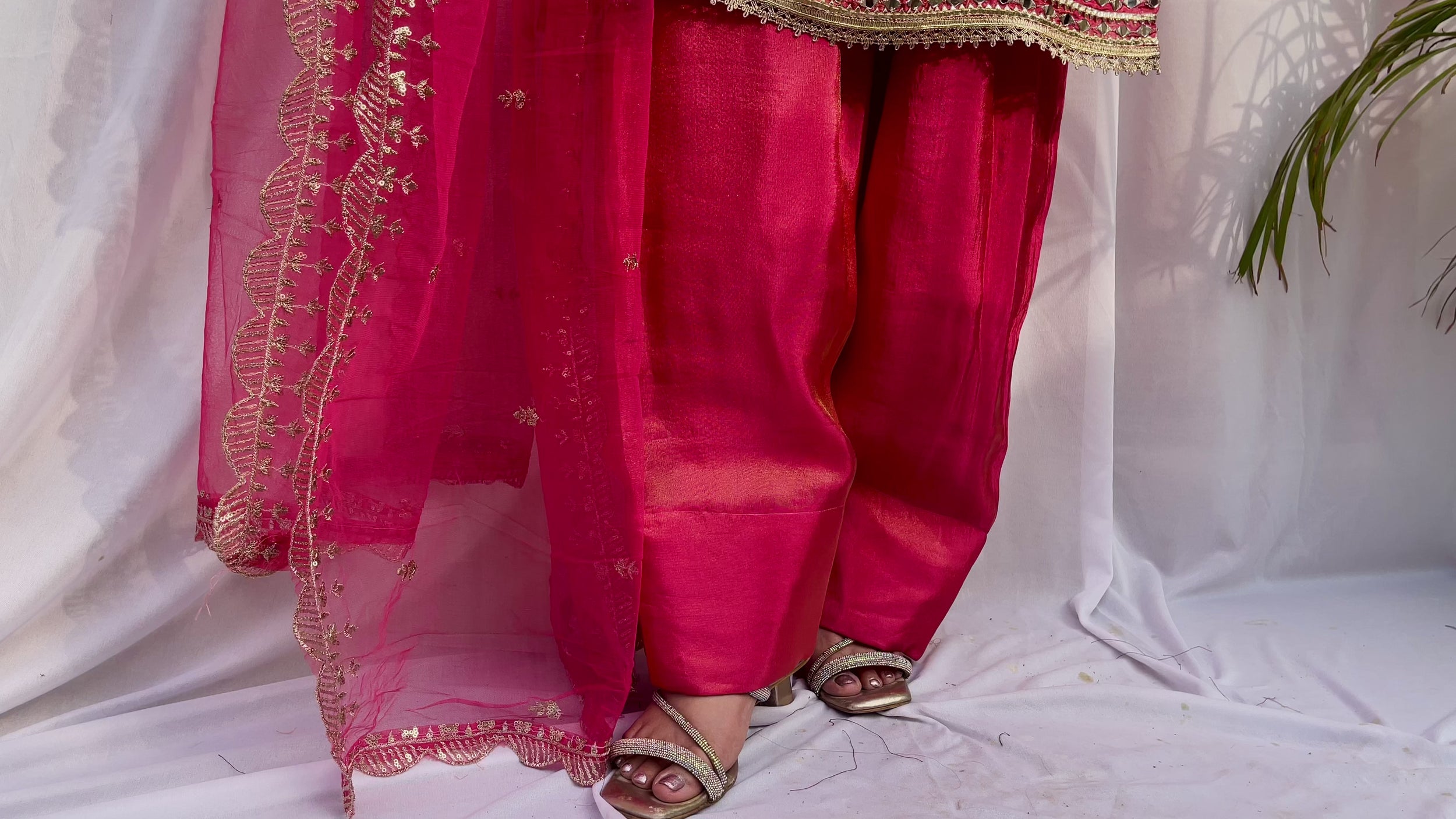 Close up of hot pink farshi salwar embroidery and dupatta border detailing with intricate threadwork