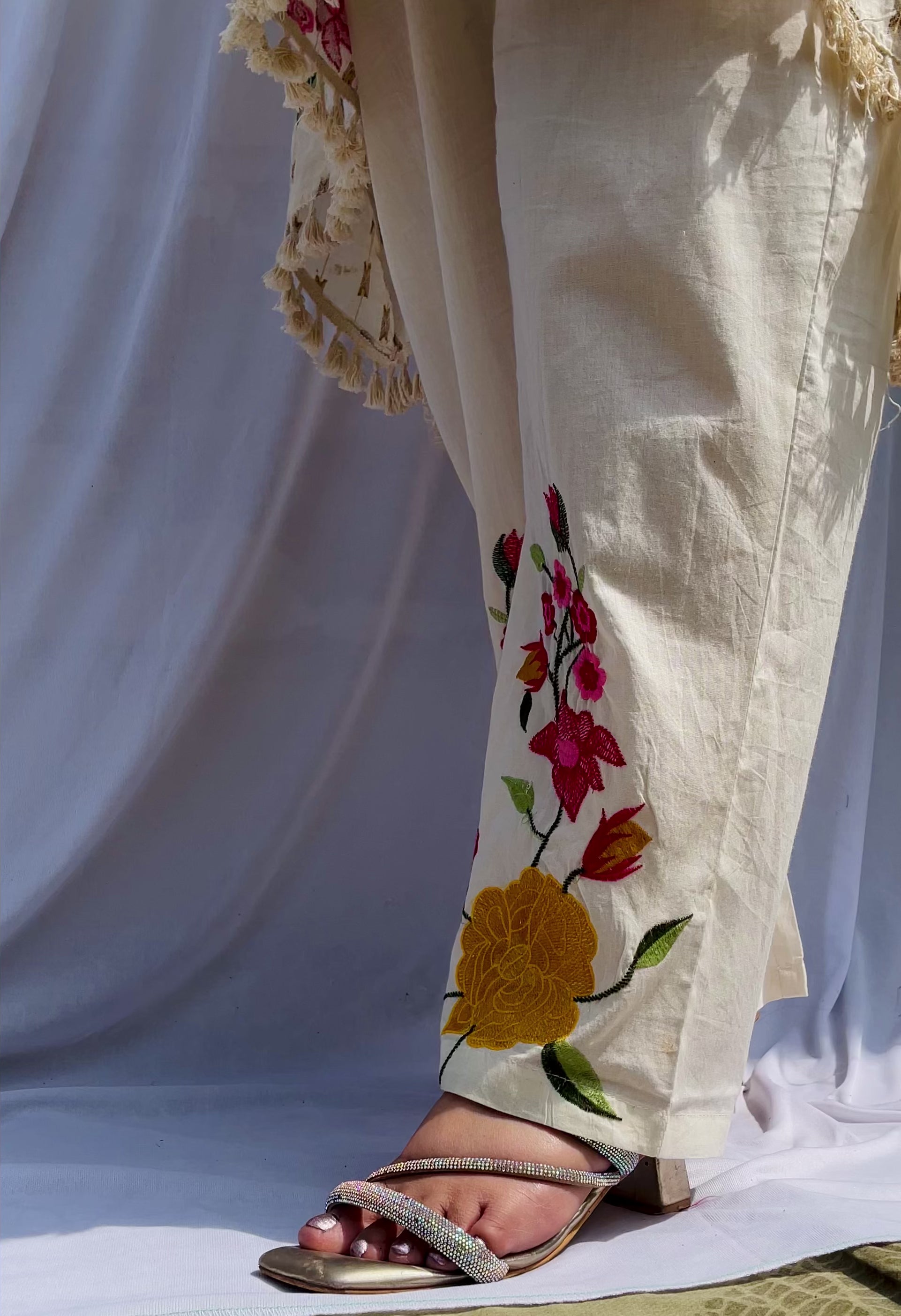Elegant ivory white chanderi silk tunic co-ord set with large colorful floral embroidery, tassel fringe, and matching embroidered pants.