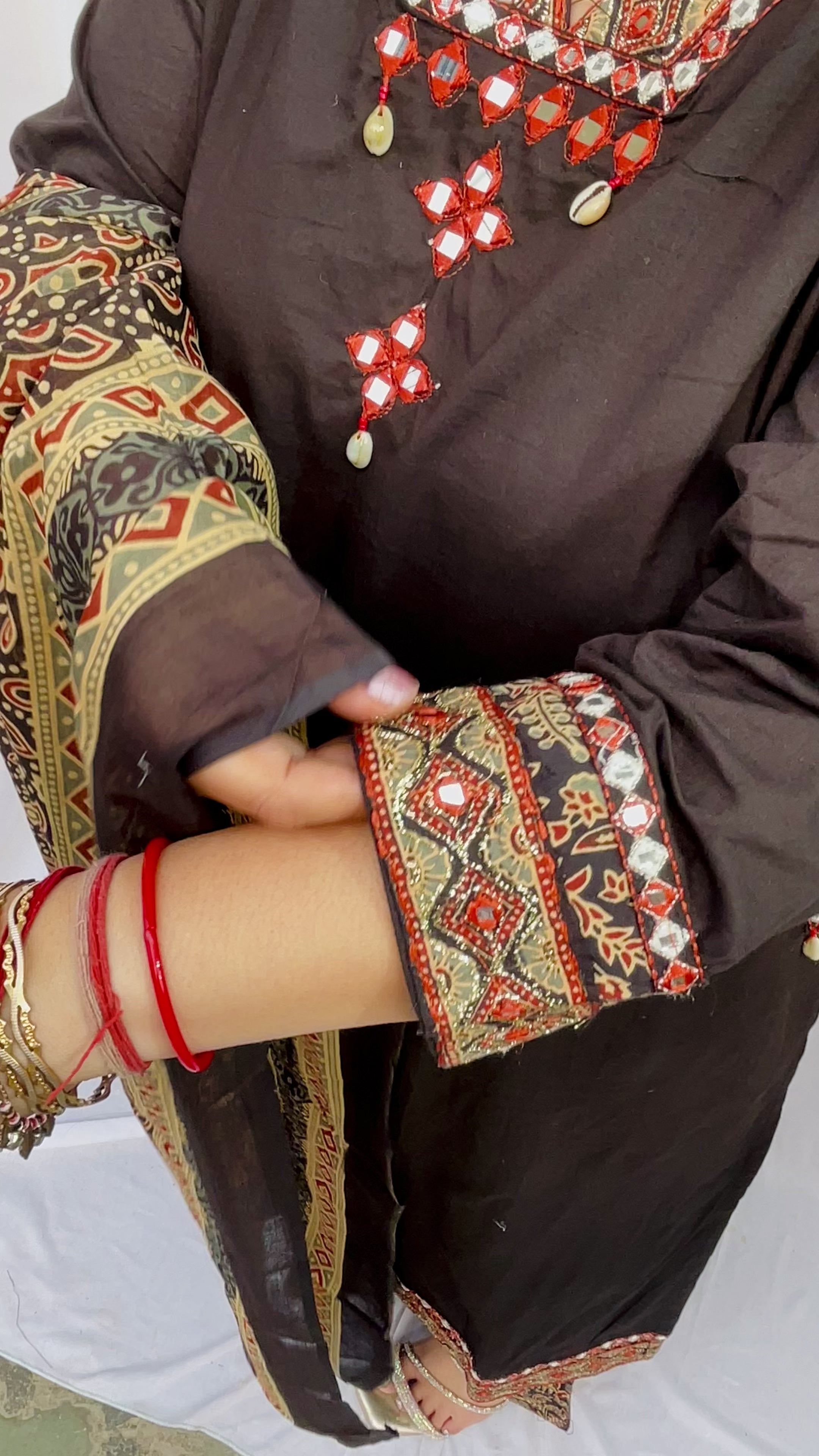 Woman wearing a black ethnic printed kurta set with matching pants and dupatta, featuring traditional motifs and a V-neck design.