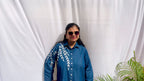 Denim-finish indigo blue shirt set with a large white leaf thread-work embroidery on the right shoulder and sleeve.
