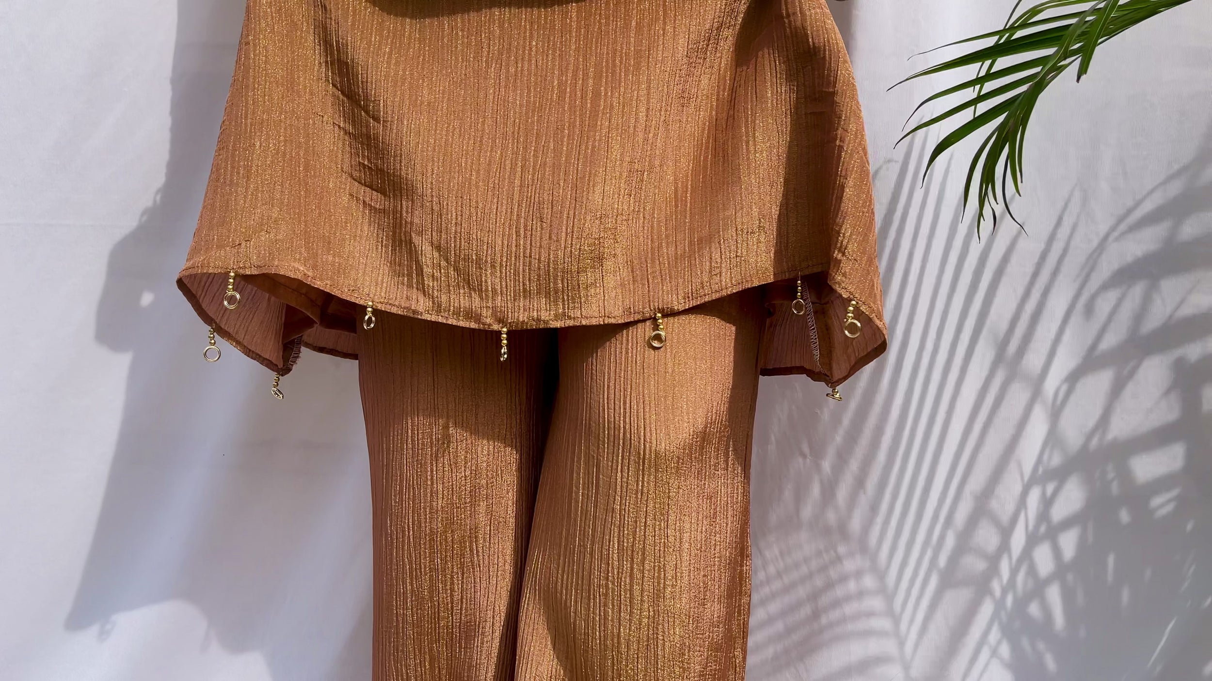 Antique gold crinkled silk ensemble with a heavily embellished sequin neckline and wide-leg flared palazzos.