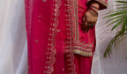 Close up of hot pink suit embroidery and dupatta border detailing with intricate threadwork