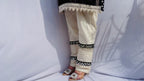 Black and white polka dot tunic featuring a V-shaped mirror work yoke, lace inserts, and matching white pants with mirror detailing.